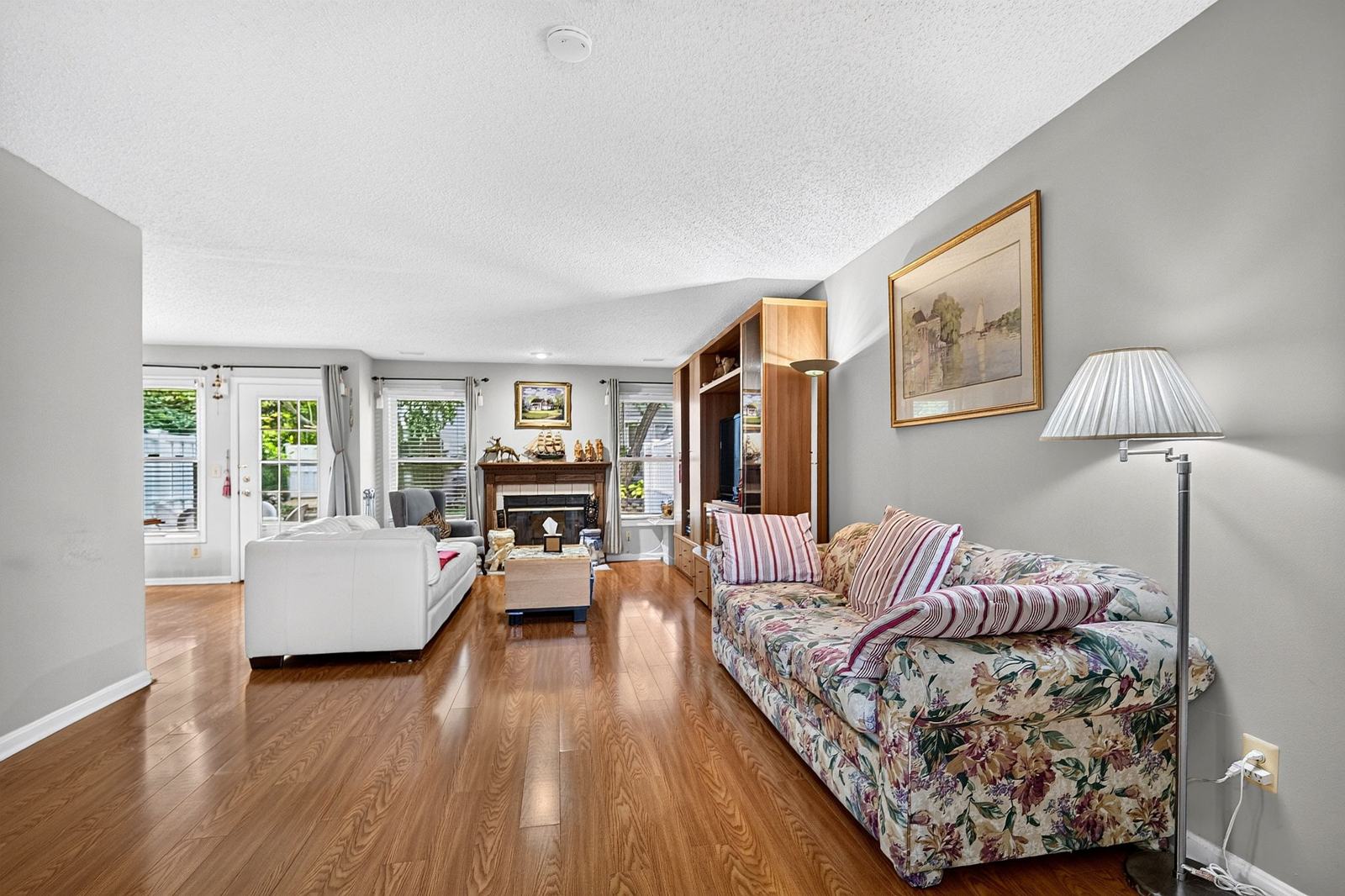 Living area with laminate flooring and windows on the back wall